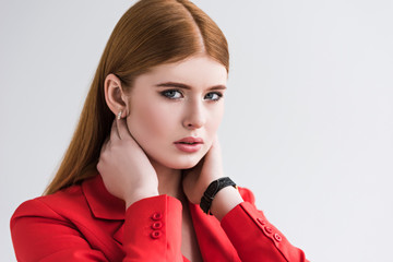 Portrait of female fashion model with wristwatch and earrings isolated on grey