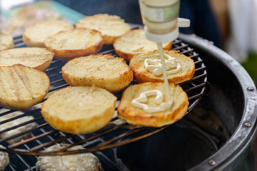 Chef making beef burgers outdoor on open kitchen international food festival event.