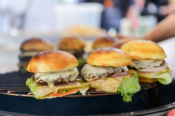 Chef making beef burgers outdoor on open kitchen international food festival event.