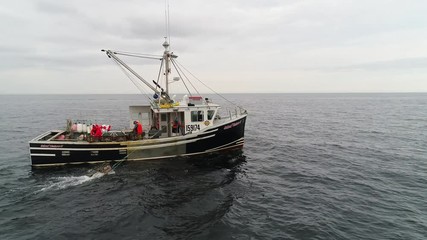 Aerial shot commercial ocean fishing boat checking lobster traps