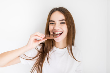 Young woman snacking on a bar of chocolate
