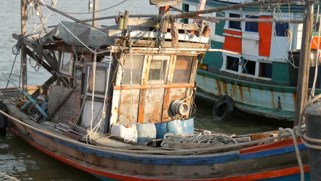 Old wooden half-ruined ship moored on a fishing dock