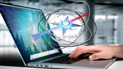 Business man using a navigation compass on a laptop - 3d rendered