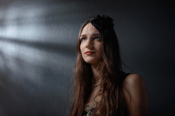 Naklejka premium Dramatic portrait of a beautiful woman in hat with veil .
