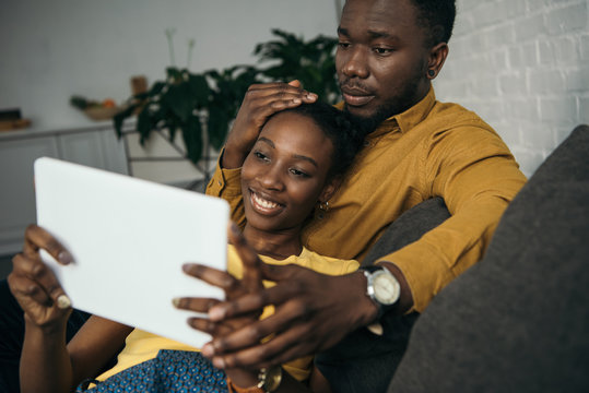 young african american couple using digital tablet together at home