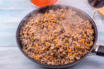 Fried minced meat on a frying pan close-up