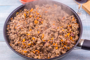 Fried minced meat on a frying pan close-up