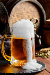Light foam beer in a glass on an old background