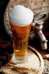 Light foam beer in a glass on an old background