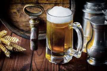 Light foam beer in a glass on an old background