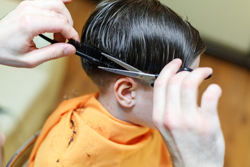 Child getting haircut at the hairdresser salon