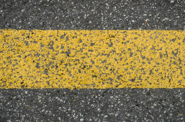 background: street detail of black gray asphalt, horizontal line painted yellow, road sign dividing...