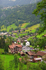 European alpine village near mountains and cliffs, Switzerland