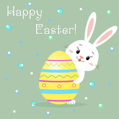 The Easter rabbit peeks out from behind a yellow decorative egg. Congratulations on Easter.