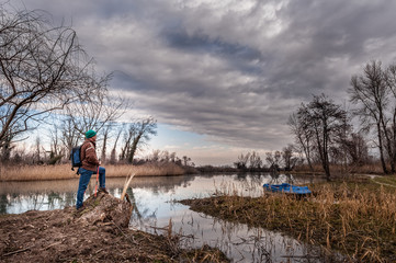 Hiker  with backpakck on riverbank.