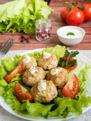 Delicious meatballs with parsley, lettuce and tomato closeup on a plate on the table. vertical