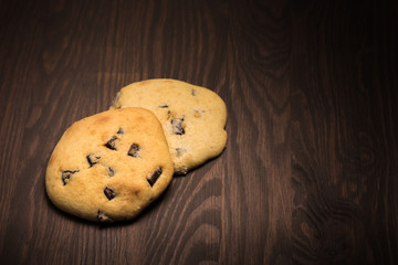 lecker selbst gemachte runde Cookies Kekse American Style mit Schokolade auf Holz im Spotlight Menü Karte