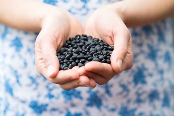 Close Up Of Woman Holding Black Turtle Beans