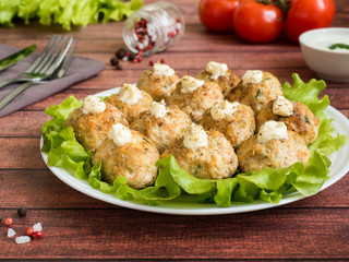 Delicious meatballs with parsley, lettuce and tomato closeup on a plate on the table. horizontal