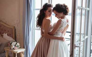 Naklejka premium Beautiful bride and bridesmaids in luxury dresses. Twins young women in wedding photosession