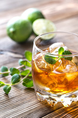 Glass of rum on the wooden background