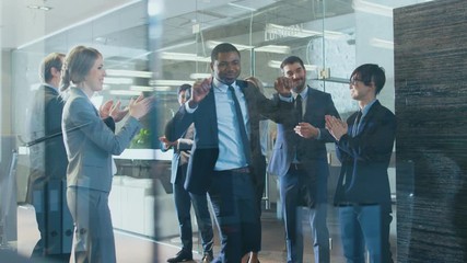 Black Businessman Got Big Promotion, Walking Path of Success, His Colleagues Cheer and Applaud. Stylish Diverse Office Filled with Happy People. Shot on RED EPIC-W 8K Helium Cinema Camera.