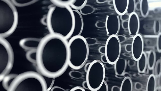 Metal pipes stacked. Heap of shiny metal steel pipes with selective focus effect. 3D animation 4k