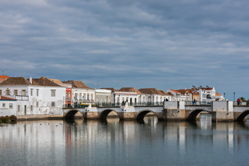 Fototapeta premium Roman bridge and historic buildings in the old center of Tavira on a cloudy day, Portugal