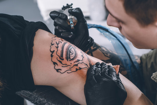 Tattoo artist in gloves working in studio