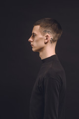 Side view of man with tattoo on temple isolated on black