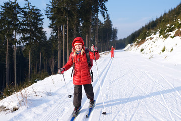 Skilangläufer mit roter Jacke  fährt Ski in Loipe am Rennsteig in Thüringen