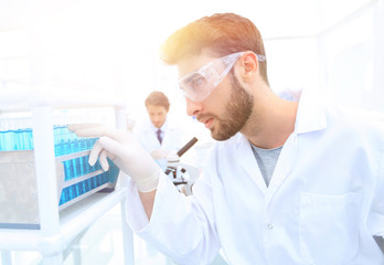 Fototapeta premium A young man doing an experiment in a chemical laboratory