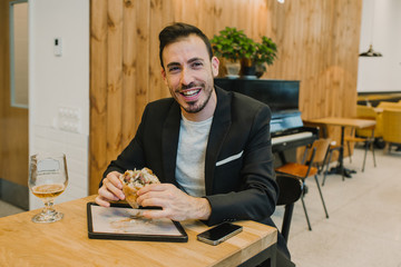 Cheerful businessman with burger