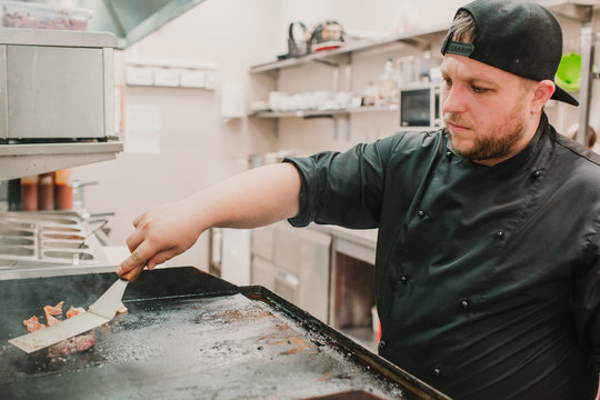 Chef turning and cooking patty