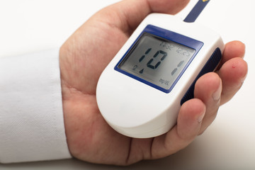 Man holding a portable digital glucose meter