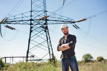 Engineer with white hard hat under the power lines.Engineer work at an electrical substation.