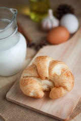 Croissant on wooden cut board on table wood and fabric select focus shallow depth of field