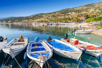 Fototapeta na wymiar Greece, traditional view of Greek coastline - small fishing boats anchored at the wooden quay. 