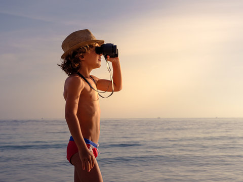 Boy with binoculars on beach