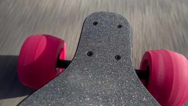 a man's feet on an electric skateboard as it moves along the ground