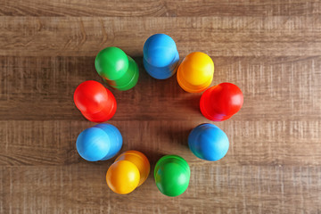 Color pawns on wooden background. Unity concept