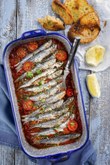 Sardinas en salsa with garlic bead as top view in a skillet