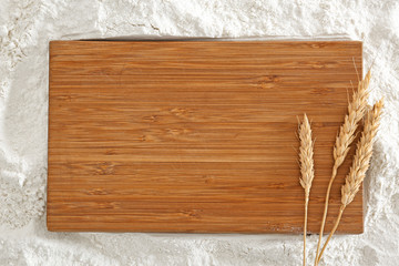 Wooden board with spikelets on flour
