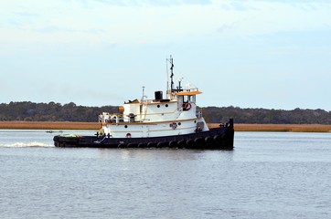 Tugboat cruising on the river background