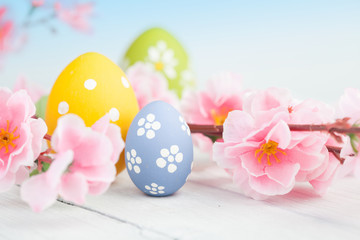 Spring flowers and colorful easter eggs on a blue