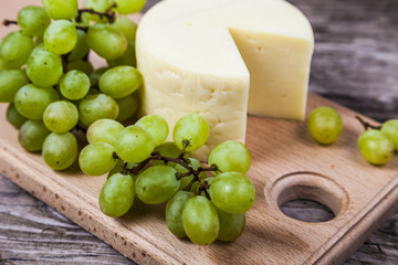 Cheese and grapes on a cutting board