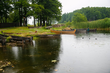 Old wooden boats on the shore of the lake near reed