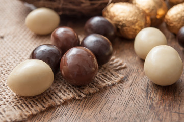 closeup of various chocolate easter egggs on wooden background