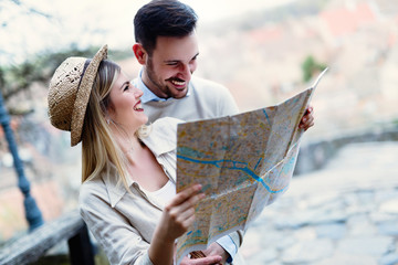 Smiling couple in love traveling with a map outdoors