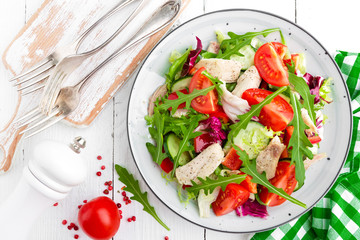 Chicken fillet salad with tomato, lettuce, cucumber and arugula leaves. Fresh vegetable salad with...